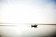 A boat of "weekend warriors" glides over the water next to the boat manned by Julius and Rebel as they leave early in the morning for alligator hunting. "Weekend warriors" is a derogatory term the locals apply to individuals who come to the river for recreation.