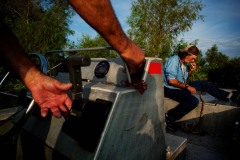 Rebel smokes a cigarette after checking a line as Julius maneuvers the boat to the next baited line on their route.