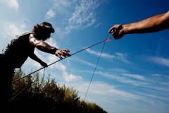 Julius hands Rebel a line while baiting a rod.